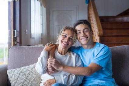 A parent and teenager sitting together at home
